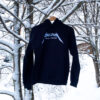 Black hoodie that reads "Bolton Valley Vermont" hangs from a snow covered tree